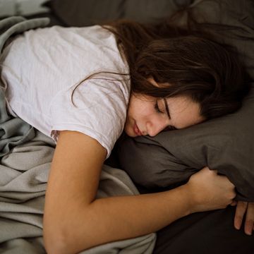 jonge vrouw ligt te slapen in bed