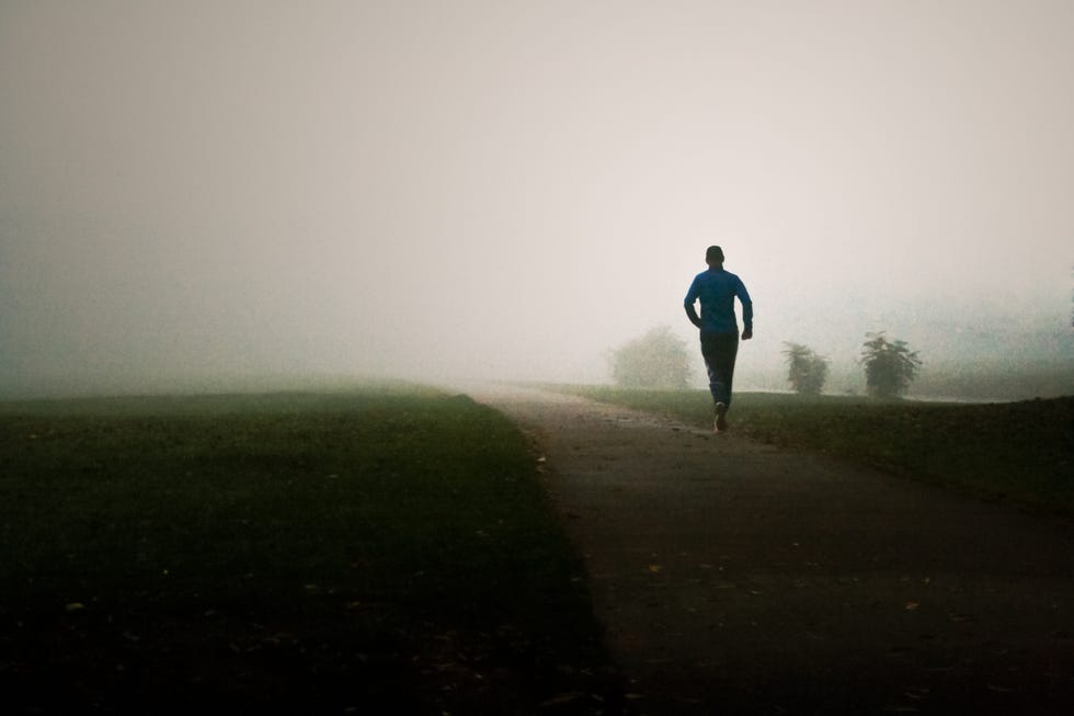 man running in foggy park