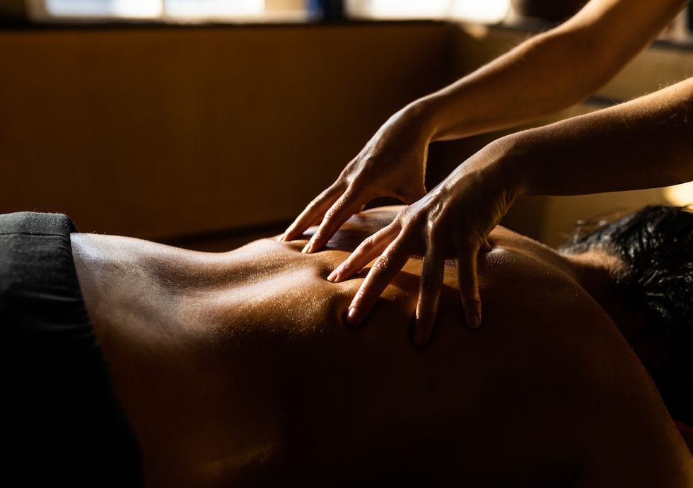 woman relaxing while receiving ayurveda massage on her back