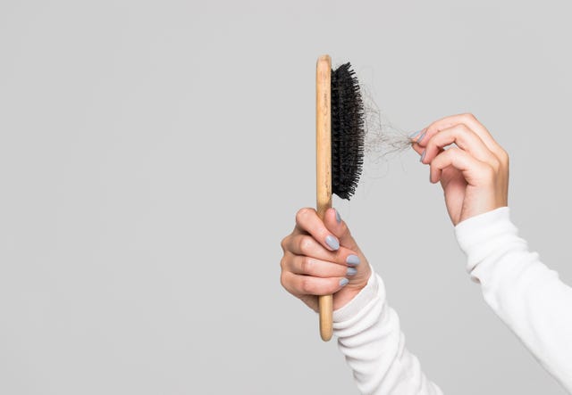 hair loss problem, postpartum period, menstrual disorder, stress many hair fall after combing in hairbrush female untangles her hair with a comb, copy space