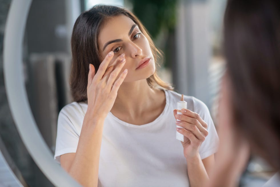 beauty routine a woman appying a concealer to her skin