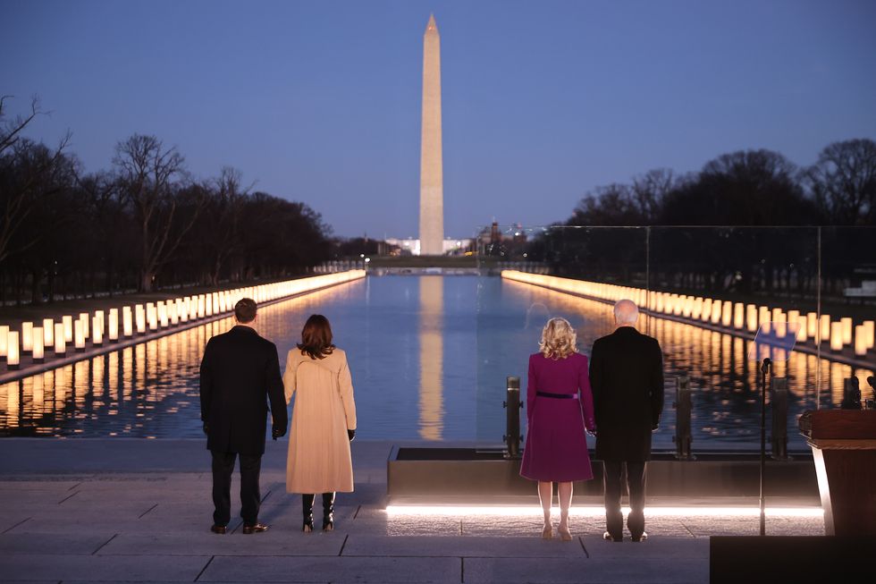 washington, dc   january 19 l r douglas emhoff, us vice president elect kamala harris, dr jill biden and us president elect joe biden look down the national mall as lamps are lit  to honor the nearly 400,000 american victims of the coronavirus pandemic at the lincoln memorial reflecting pool january 19, 2021 in washington, dc as the nations capital has become a fortress city of roadblocks, barricades and 20,000 national guard troops due to heightened security around bidens inauguration, 400 lights were placed around the reflecting pool to honor the nearly 400,000 americans killed by covid 19 photo by chip somodevillagetty images