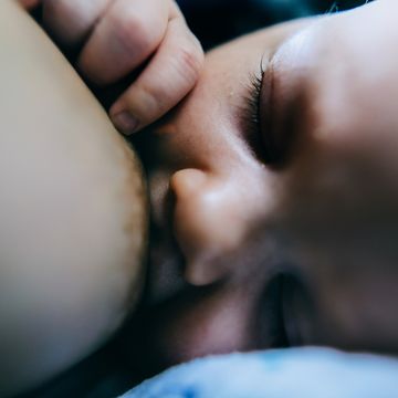 woman breastfeeding her newborn baby daughter, close up