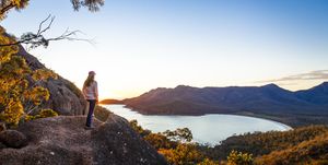 een vrouw kijkt uit over wineglass bay in tasmanië