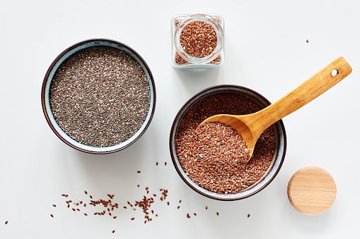 flax seeds and chia seeds in bowls, top view