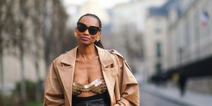 paris, france   february 17 emilie joseph wears sunglasses, golden earrings, a beige trench coat from gestuz, bronze shiny metallic bras as part of a dress from paco rabanne, black leather cropped pants from sportmax, on february 17, 2021 in paris, france photo by edward berthelotgetty images