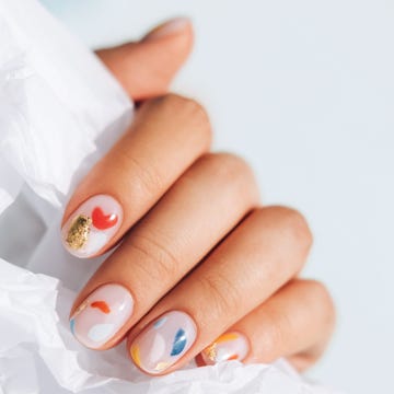 Woman hand with beautiful colorful manicure is holding white paper. Trendy bright colors of the year woman hand with beautiful colorful manicure is holding white paper trendy bright colors of the year