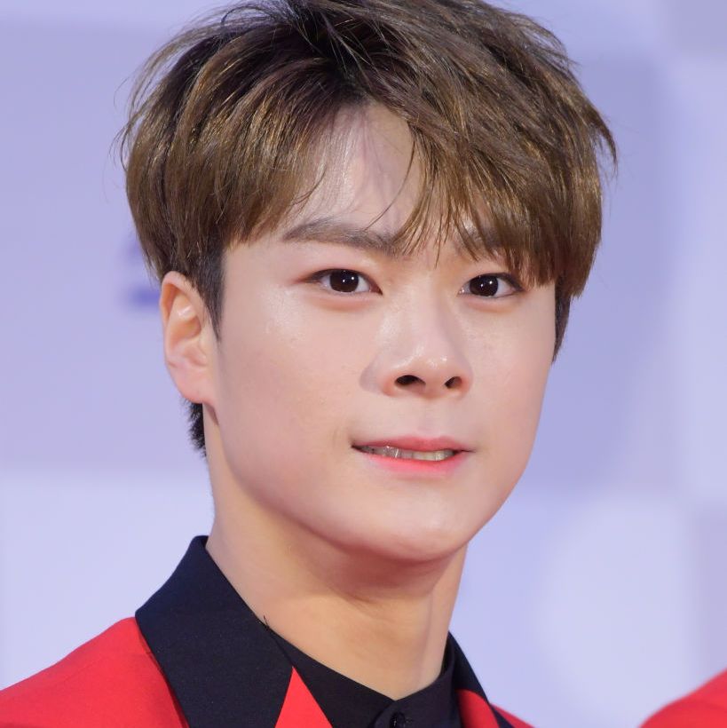 k pop star moonbin attending music awards wearing a red jacket