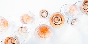 sparkling rose wine in different glasses on white background