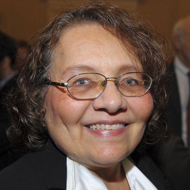 diane nash smiles at the camera in a closeup photo, she wears a black and white top and wire rimmed glasses