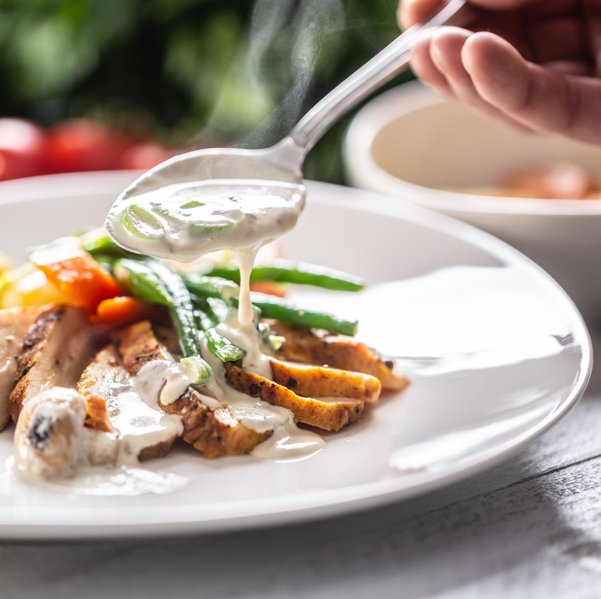chicken breasts cooked with fresh vegetable and served with a mushroom sauce on a plate