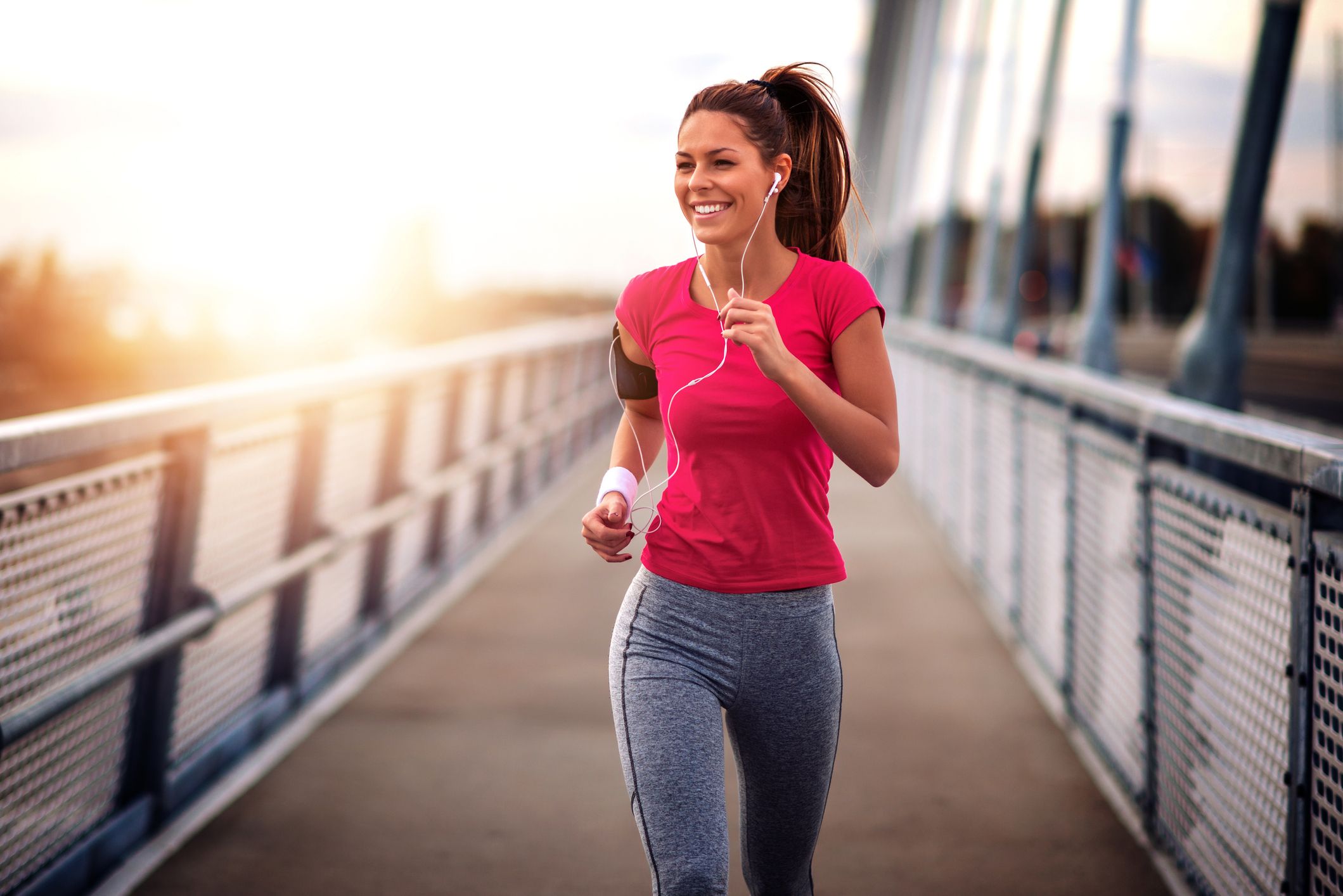 young woman jogging outdoors on bridge concept of healthy lifestyle