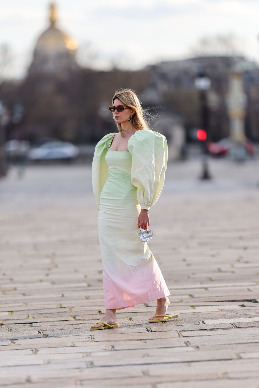 paris, france   march 25 natalia verza mascaradaparis wears sunglasses, a pastel colored green and pink oversized tie and dye midi dress with low neck and puff large sleeves from sandra mansour x agl, a silver shiny mini bag, yellow flip flop sandals, during a street style fashion photo session, on march 25, 2021 in paris, france photo by edward berthelotgetty images