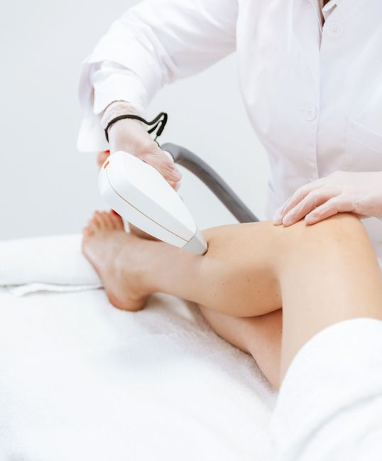 woman getting laser treatment on her legs, beauty concepts, medical laser hair removal cosmetology procedure from a therapist at cosmetic beauty spa clinic laser epilation and cosmetology