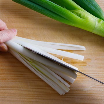 japanese-kitchen-knives woman cutting spring onion using japanese kitchen knife