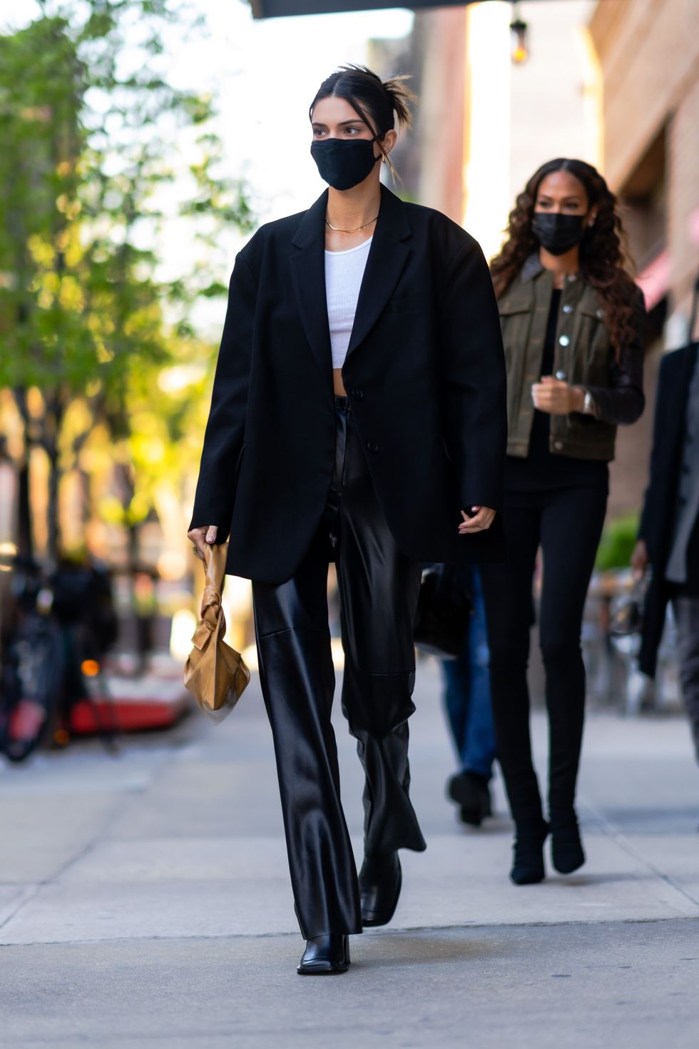 Kendall Jenner in black coat with black patent shoulder bag by far