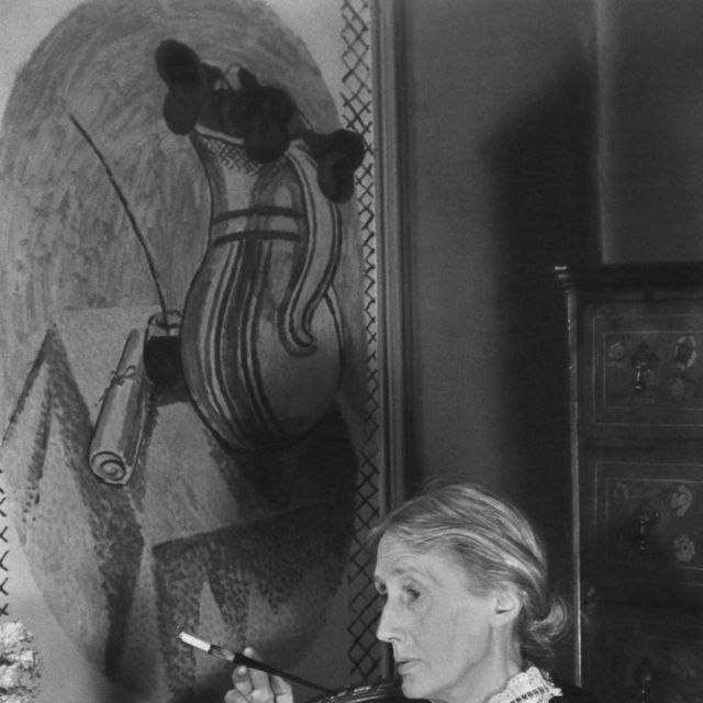 retrato de la escritora británica virginia woolf 1882 1941 mientras fuma un cigarrillo con un libro abierto en su regazo, londres, inglaterra, 1939 en la pared detrás de ella hay un fresco pintado por su hermana, vanessa bell foto de gisele freund