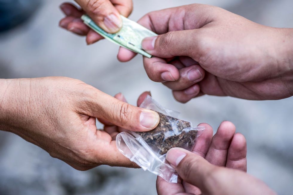 a group of hands holding a clear plastic bottle