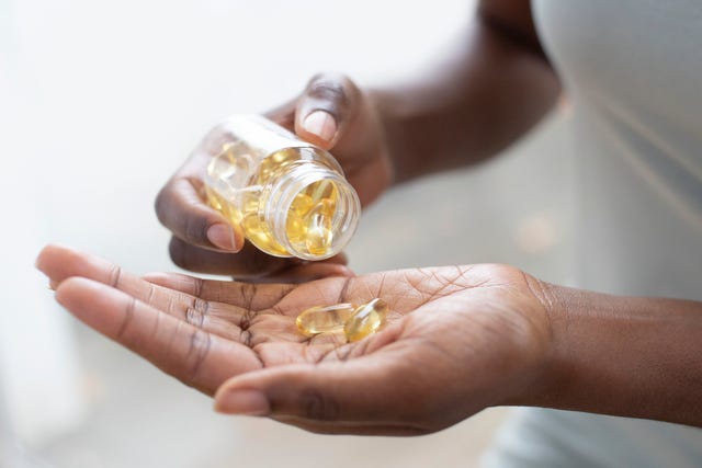 woman pouring capsules into her hand