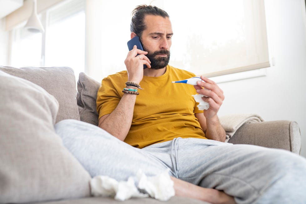 A man sitting on the sofa holding a remote control
