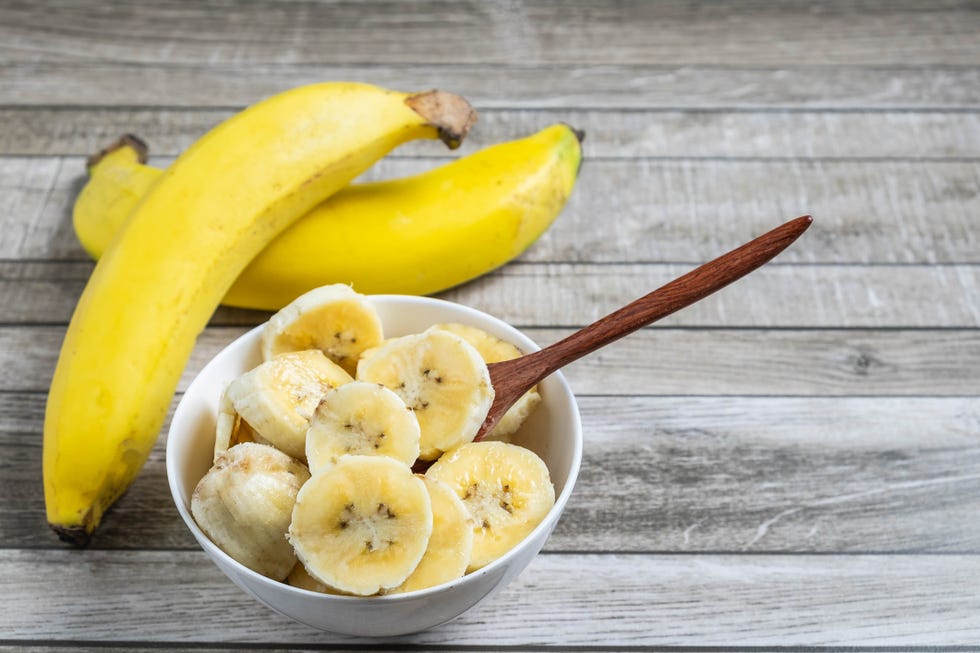 fresh bananas and bananas cut into pieces in a bowl for health on the table