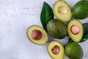 avocado and avocado leaves on a white background