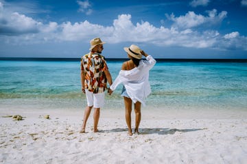 couple of men and woman mid age on the beach of curacao, grote knip beach curacao dutch antilles caribbean on a tropcial beach with white sand