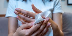 close up hand of asian woman using wet tissue paper wipe cleaning her handshealthcare medicine body care concept