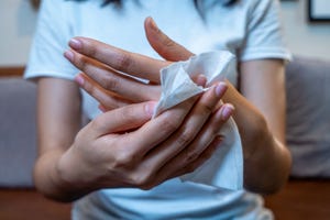 close up hand of asian woman using wet tissue paper wipe cleaning her handshealthcare medicine body care concept