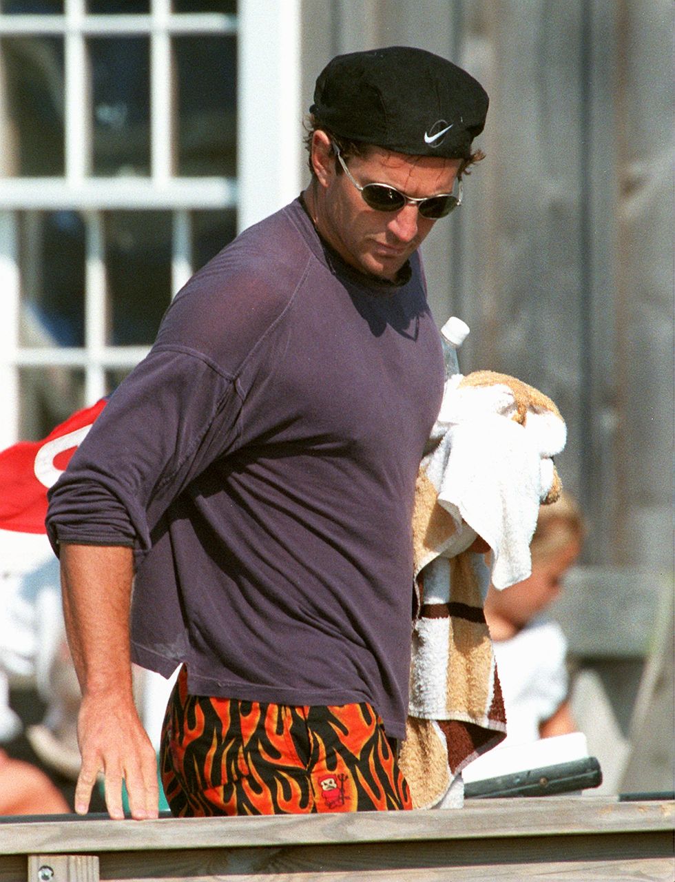 hyannis port   august 23 john kennedy, jr walks along a pier near the kennedy compound after a few hours of sailing off hyannis port the kennedy clan gathered for the annual get together at the compound photo by john tlumackithe boston globe via getty images