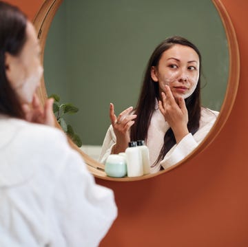 Woman applying moisturiser woman applying moisturiser