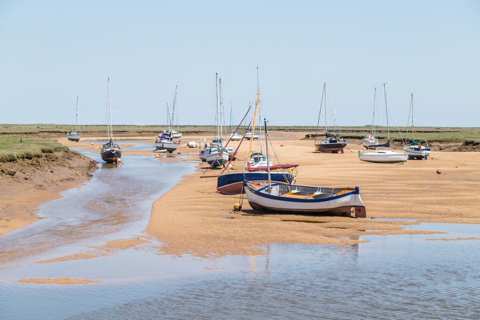 boats by the quay at wells next the sea seen at low tide in june 2021 on the north norfolk coast for renault article