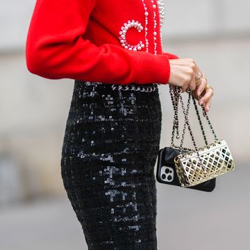 paris, france   july 06 leonie hanne wears a red wool pullover with embroidered white pearls to sign chanel, black tweed with embroidered checkered sequins flared knees pants, gold rings, a metallic checkered mesh chanel handbag, a black shiny leather chanel phone case crossbody bag, outside chanel, during paris fashion week   haute couture fallwinter 20212022, on july 06, 2021 in paris, france photo by edward berthelotgetty images