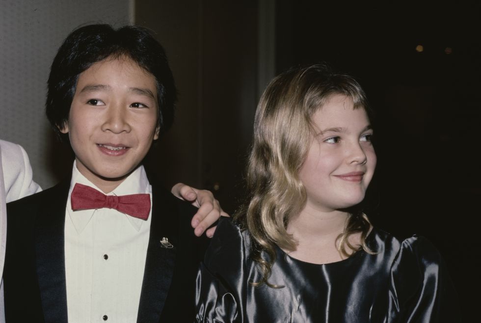 american actor ke huy quan, wearing a tuxedo with a red bow tie, and american actress drew barrymore, wearing a grey silk outfit with a round neckline, attend the 6th youth in film awards, in los angeles, california, 2nd december 1984 barrymore is nominated for the best young actress in a motion picture musical, comedy, adventure or drama award for her performance in irreconcilable differences, and quan is nominated for the best young supporting actor in a motion picture musical, comedy, adventure or drama award for his performance in indiana jones and the temple of doom photo by vinnie zuffantemichael ochs archivesgetty images