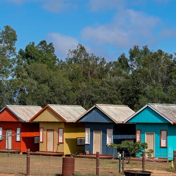 Tiny Homes a row of colorful tiny houses in a rural area, each with their own front door and small porch deck