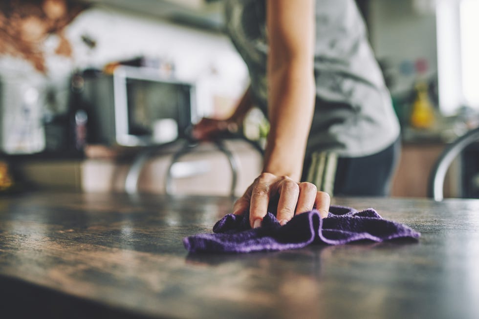 close up of a hand with a rag wiping a table