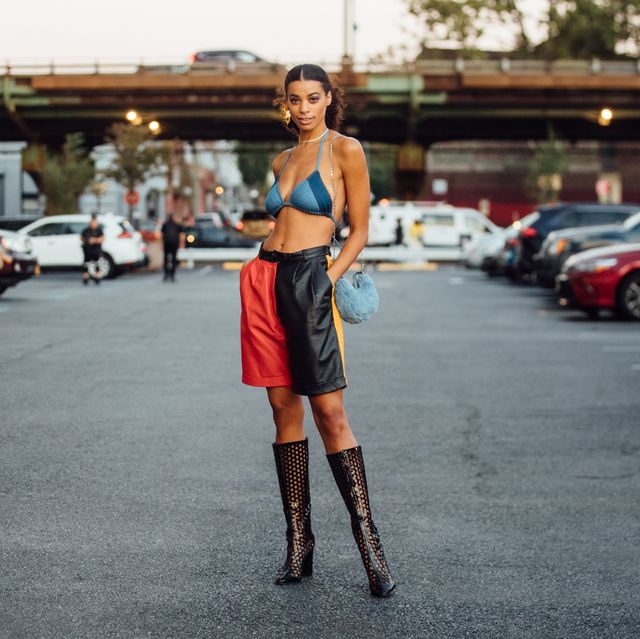 new york, new york   september 07 model nakisa kachingwe wears a blue denim bikini top, red and black leather shorts, black see through heeled boots, and carries a small baby blue fuzzy purse outside the collina strada show on september 07, 2021 in new york city photo by melodie jenggetty images