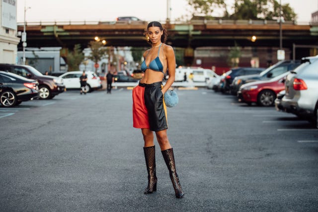 new york, new york   september 07 model nakisa kachingwe wears a blue denim bikini top, red and black leather shorts, black see through heeled boots, and carries a small baby blue fuzzy purse outside the collina strada show on september 07, 2021 in new york city photo by melodie jenggetty images