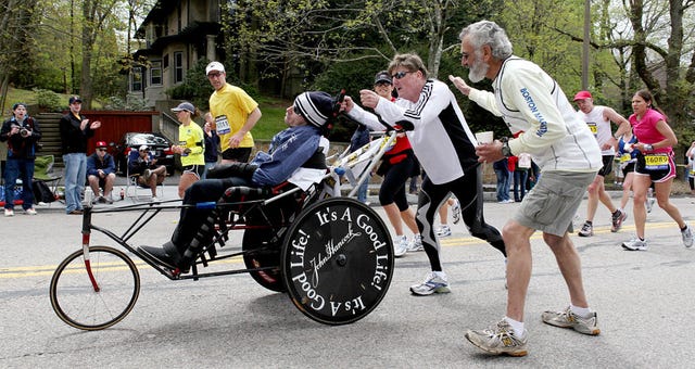 041910 boston, ma dick hoyt gets a pat on the back and a cheer as he pushes his son, dick, up heartbreak hill during the 114th boston marathon, monday, april 19, 2010 staff photo by angela rowlings photo by angela rowlingsmedianews groupboston herald via getty images