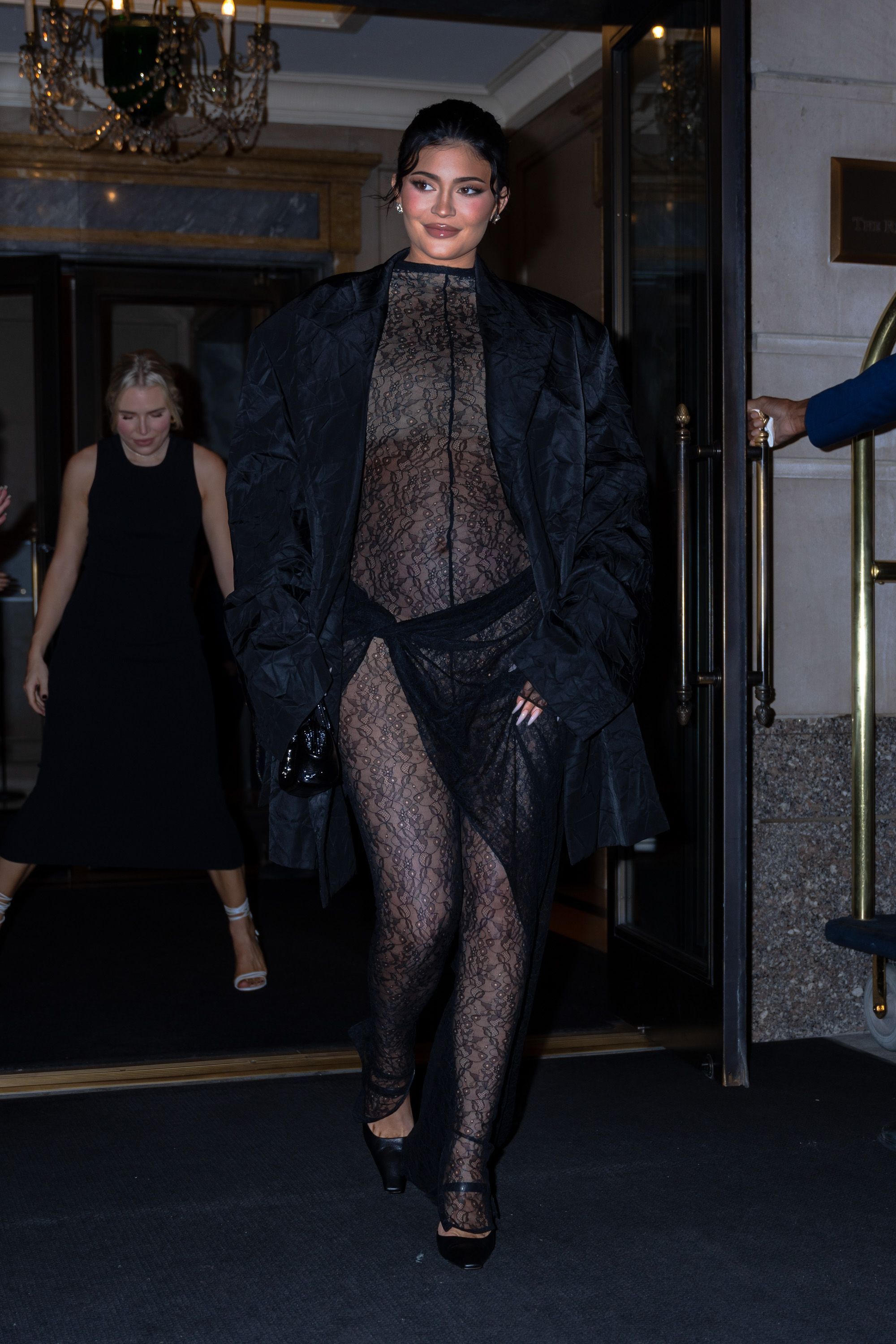 Kylie Jenner stuns in a sheer lace jumpsuit with a black duster