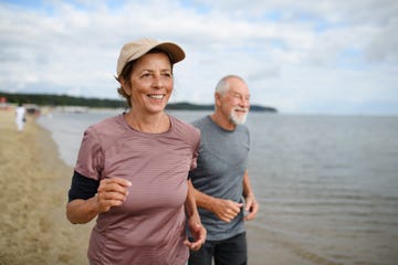 active senior woman and man running outdoors sea