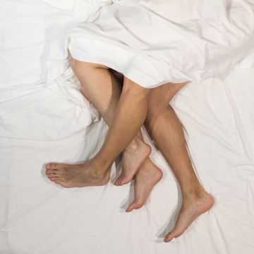 high angle view of legs and feet of young man over legs and feet of woman in bedroom madrid, spain, europe