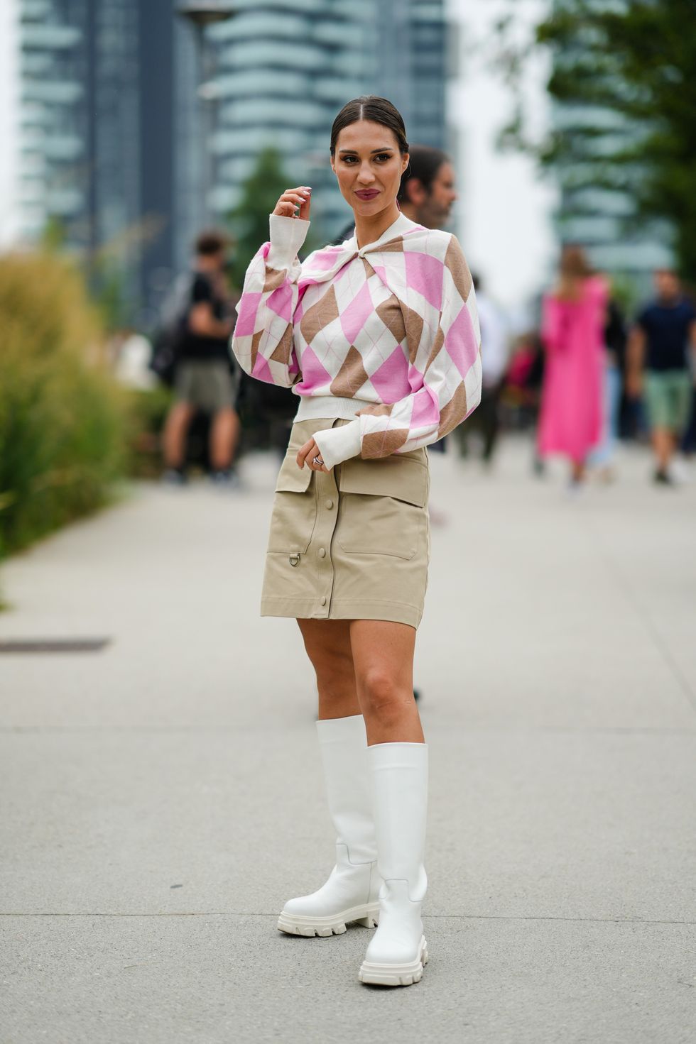 milan, italy   september 25 a guest wears white with brown and pale pink diamond  jacquard print pattern pullover, a beige shiny leather buttoned  studded  skirt with large pockets, silver rings, white shiny leather knees boots, outside the msgm fashion show during the milan fashion week   spring  summer 2022 on september 25, 2021 in milan, italy photo by edward berthelotgetty images