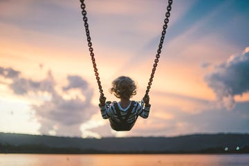 boy on swing against sky