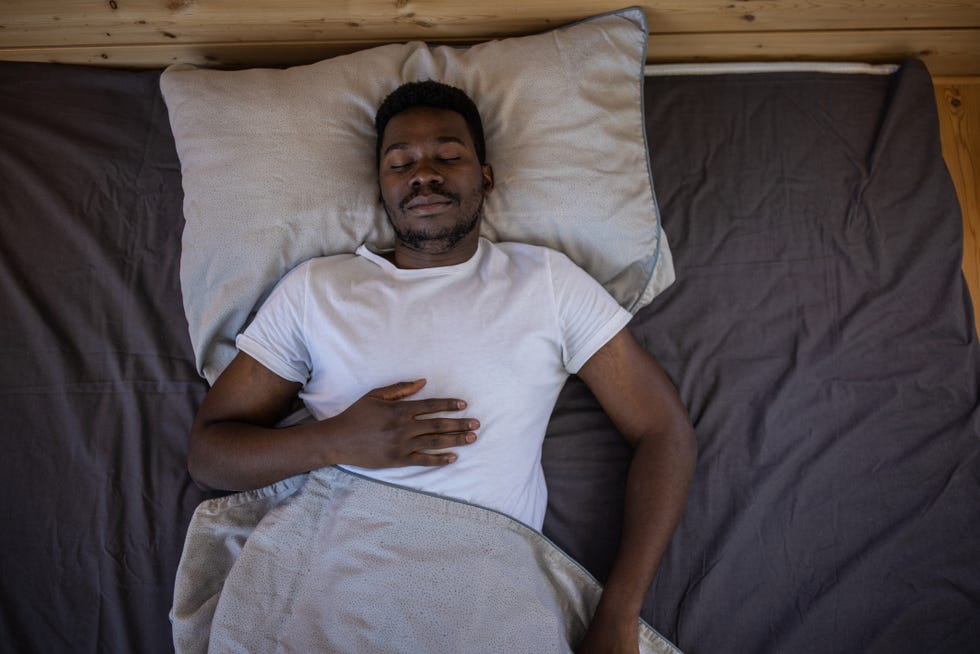 high angle view of young man sleeping in bed at home