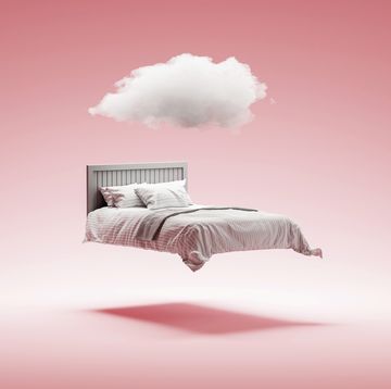 a floating bed with a cloud over it and a salmon pink background