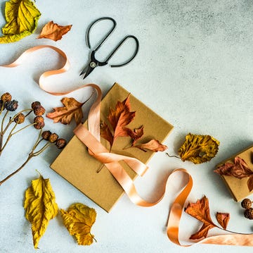 Autumnal gift box tied with a ribbon and dried autumn leaf decorations on a table diy fall decorations