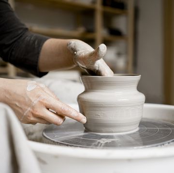 woman making pot on pottery wheel
