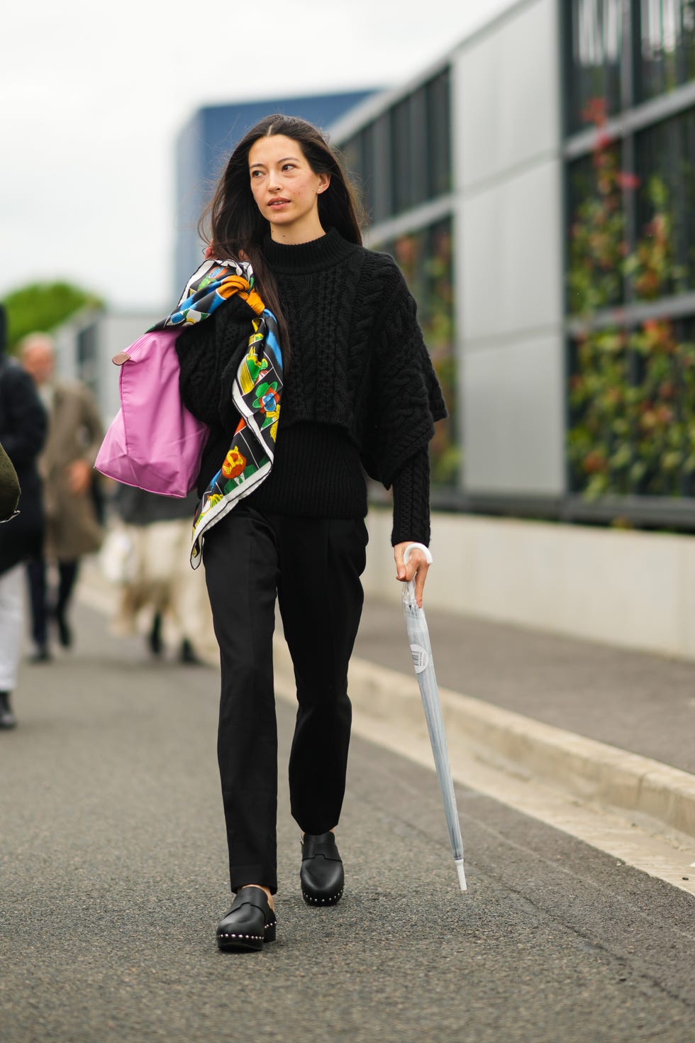 paris, france october 02: a guest wears a black wool pullover, a pink longchamp large handbag, black pants, a multicolored print pattern silk scarf, black leather nailed / studded mules from hermes, a white umbrella, outside hermes, during paris fashion week womenswear spring summer 2022, on october 02, 2021 in paris, france. (photo by edward berthelot/getty images)