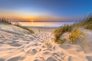 inviting sunset view over ocean from dune over north sea and canal in ouddorp, zeeland province, the netherlands outdoor scene of coast in nature of europe